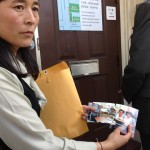 Lhamo Tso showing pictures of her children. Chinese Consulate in San Franciso (photo: Filming for Tibet)