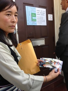 Lhamo Tso showing pictures of her children. Chinese Consulate in San Franciso (photo: Filming for Tibet)